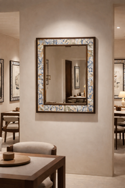 Decorative mirror with floral frame on a wall in a room with furniture.